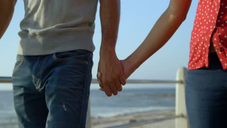 Mid-section-of-mixed-race-couple-holding-hands-4k