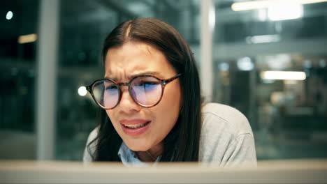 Woman looking at computer screen with a frustrated expression