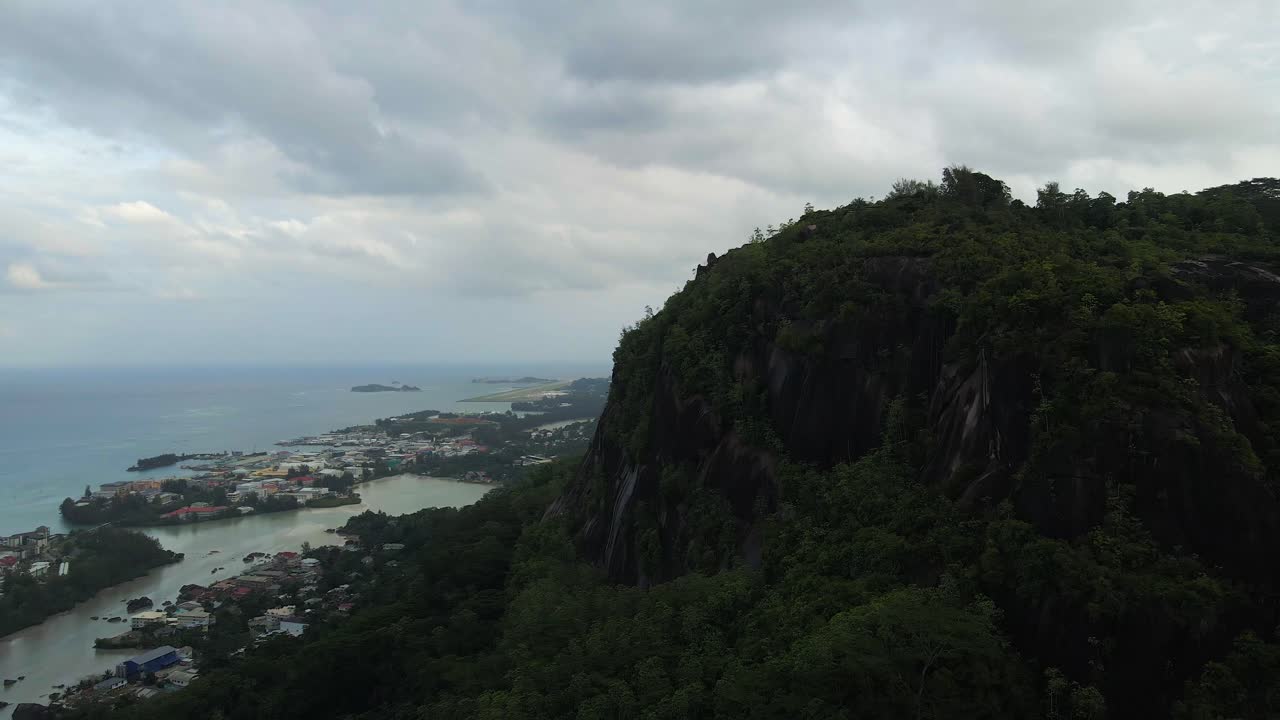 세이 ⁇ 의 풍경은 위에서 드론으로 촬영되어 주요 섬 마헤의 자연, 산, 집 및 섬을 보여줍니다.