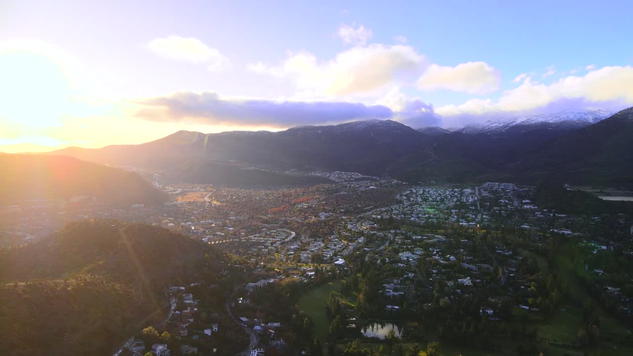 드론이 칠레 산티아고의 부유한 교외에서 해가 지는 동안 날아다니고 있습니다.
