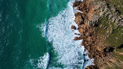 Cornwall's-Coastline-with-Overhead-Top-Down-View-from-an-Aerial-Drone-with-Ocean-Waves-and-Cliffs