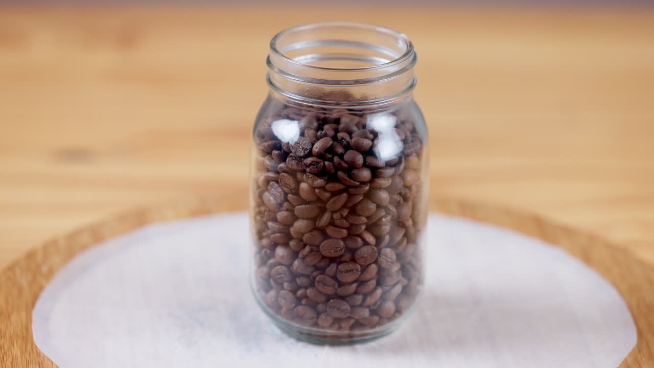 café, frijoles y primer plano en el recipiente del frasco