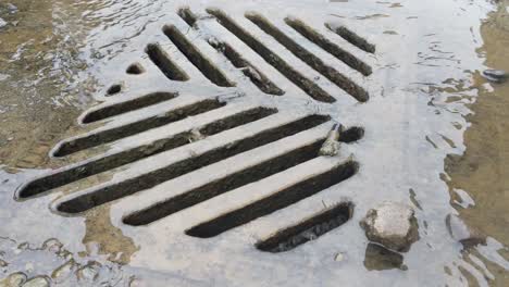 agua que fluye hacia un desagüe pluvial en un sitio de construcción