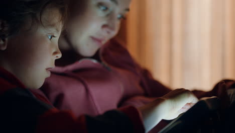 mother and child using tablet computer mom teaching little girl playing games on touchscreen technology having fun before bedtime