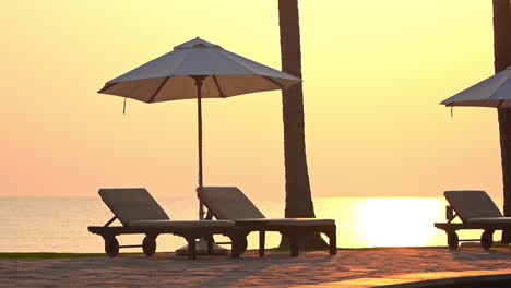 close-up of empty beach loungers and sun umbrella at sunset