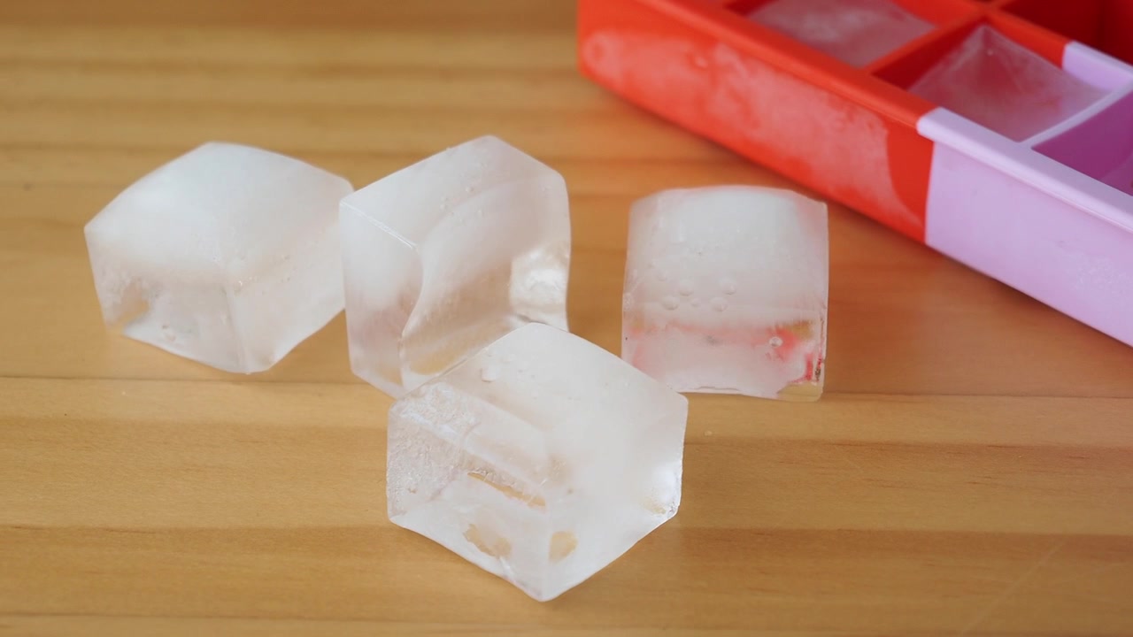 Cubos de Gelo Derretendo em uma Mesa de Madeira ao Lado de uma Bandeja
