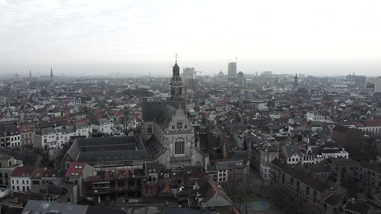 Slow aerial flight above antwerp city in direction saint paul cathedral on foggy day