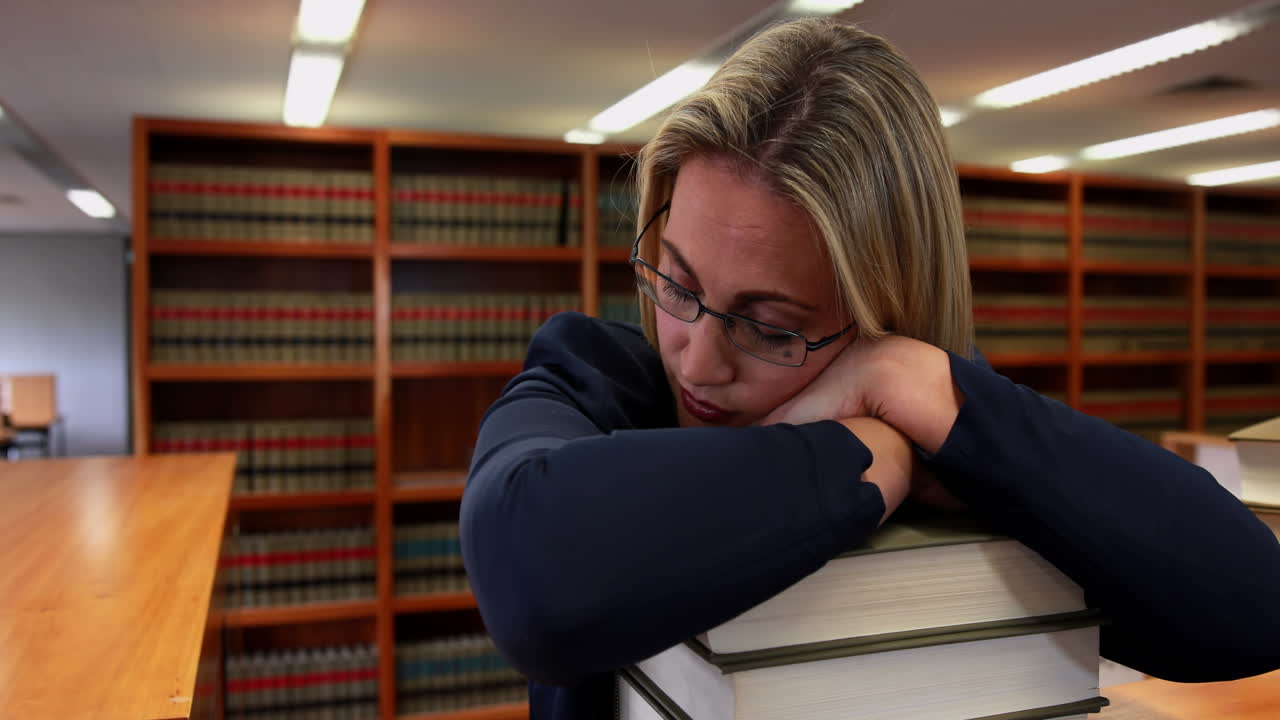 Bibliotekar sover på bøkene sine