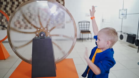 the boy examines the perpetual motion machine. science exhibition museum