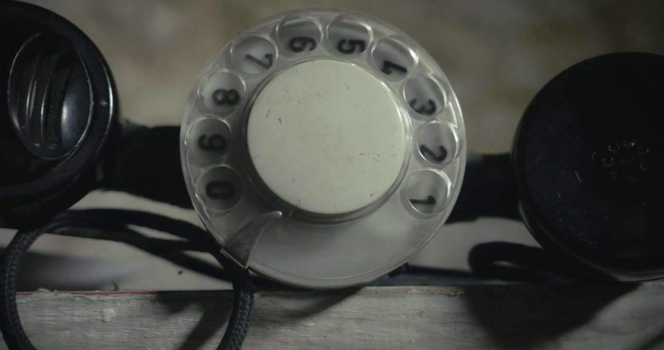 Gros plan en travelling révélant un téléphone d'ingénieur rétro dans une lumière tamisée, créant un visuel atmosphérique pour les productions policières, d'espionnage, de mystère et de thriller.