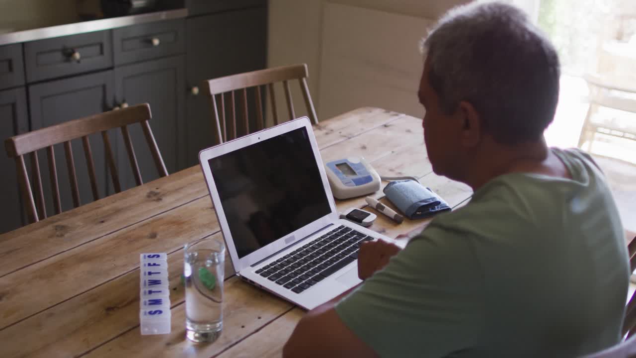 Senior mixed race man having online medical consultation using laptop