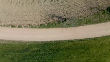 aerial birds eye dolly right shot over dirt road during day