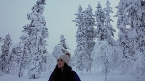 hermosa chica explorando el paisaje en el bosque nevado en laplandia, finlandia, círculo ártico