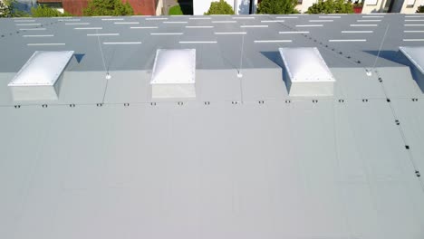 Fliegen-Neben-Einem-Großen-Dach,-Das-Mit-Isolierplatten-Isoliert-Ist,-Und-Großen,-Leichten-Verbundkuppeln-Auf-Der-Oberseite