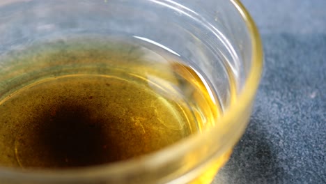 close-up of a glass bowl filled with yellow oil