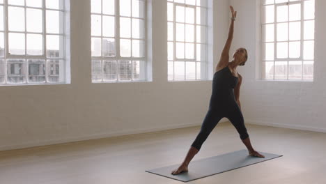 beautiful yoga woman practicing reverse warrior pose enjoying fitness lifestyle exercising in studio stretching flexible body training early morning meditation on exercise mat