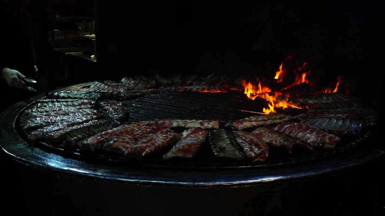 Costine di maiale che arrostiscono sul fuoco, barbecue. Rallentatore