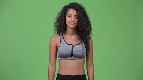 young beautiful hispanic woman with gym clothes giving handshake