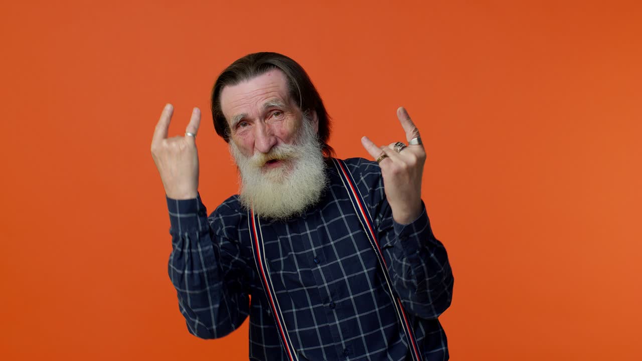 encantado encantado loco anciano mostrando gesto de rock n roll con las manos, signo fresco, baile