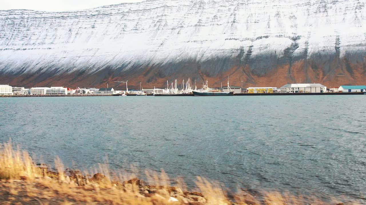isafjordur, westfjords, isafjordur의 물과 눈 덮인 산 근처 아이슬란드의 작은 마을의 느린 이동 샷