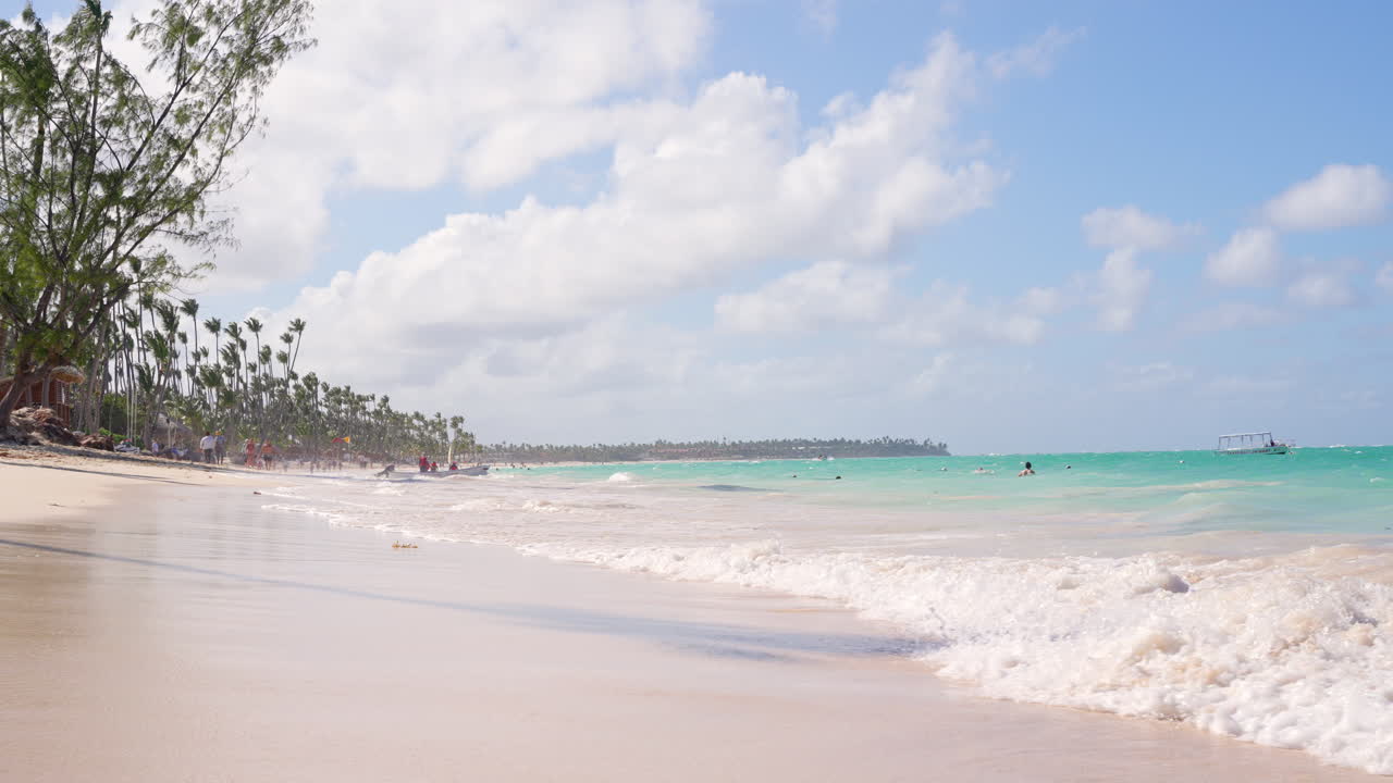 вид под низким углом на волны, бьющиеся о пляж баваро в пунта-кане