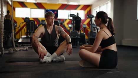 man and woman talking in a gym