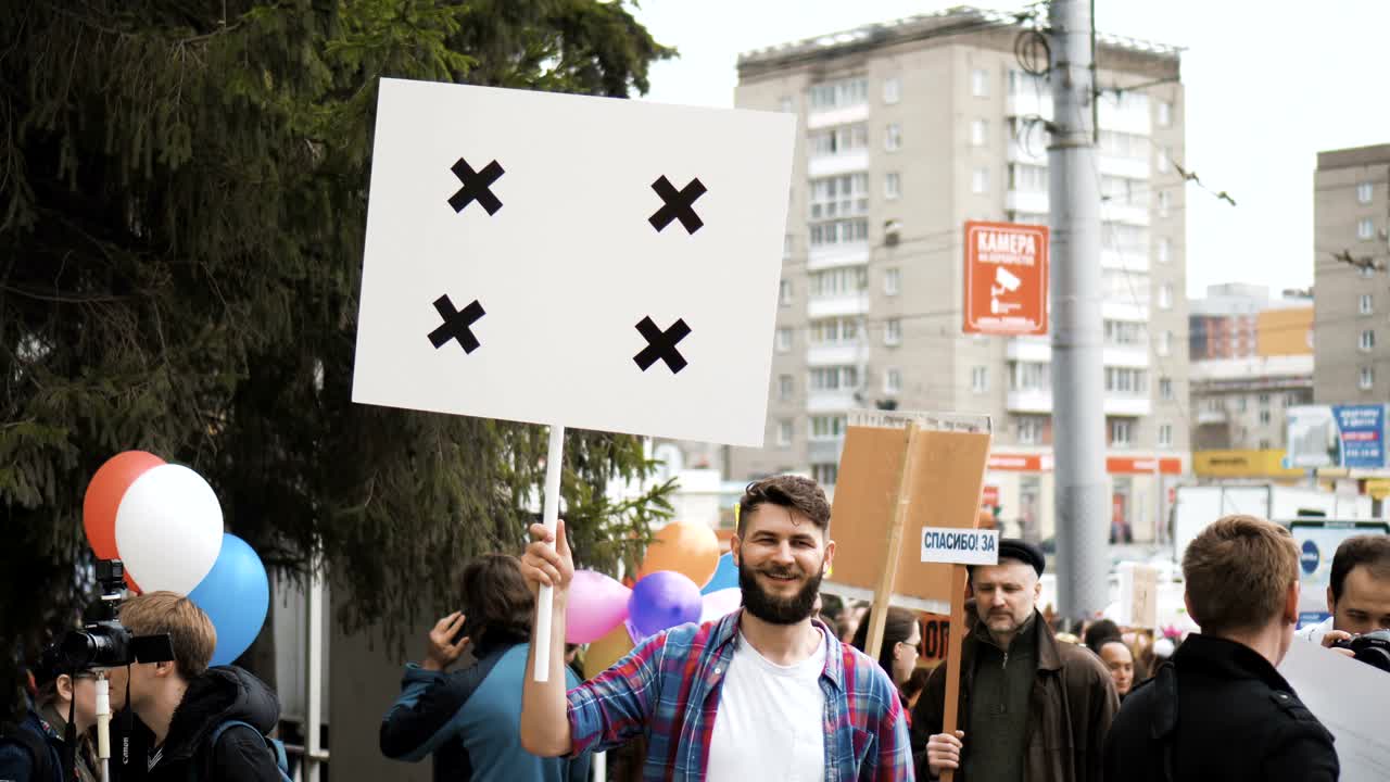 gente europea en la manifestación. hombre con una pancarta gritando en una boquilla.