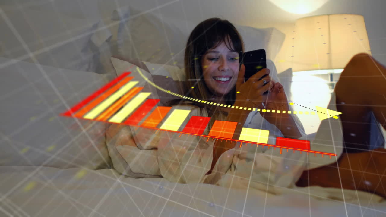 animación de flecha en el gráfico de caída, mujer biracial sonriente acostada en la cama y desplazándose en el teléfono celular
