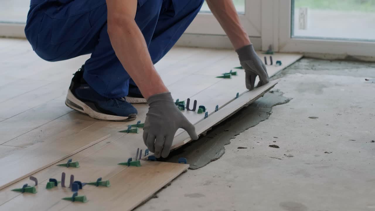 Installing ceramic floor tiles - measuring and cutting the pieces. Construction, renovation, repair apartment. Cuts tile. Tile cutting