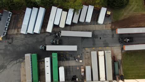 top down aerial drone view of freight trailers at distribution center, logistics and transportation, e-commerce theme