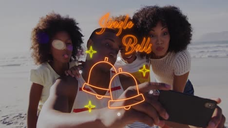 animation of jingle bells over happy african american family taking selfie on beach