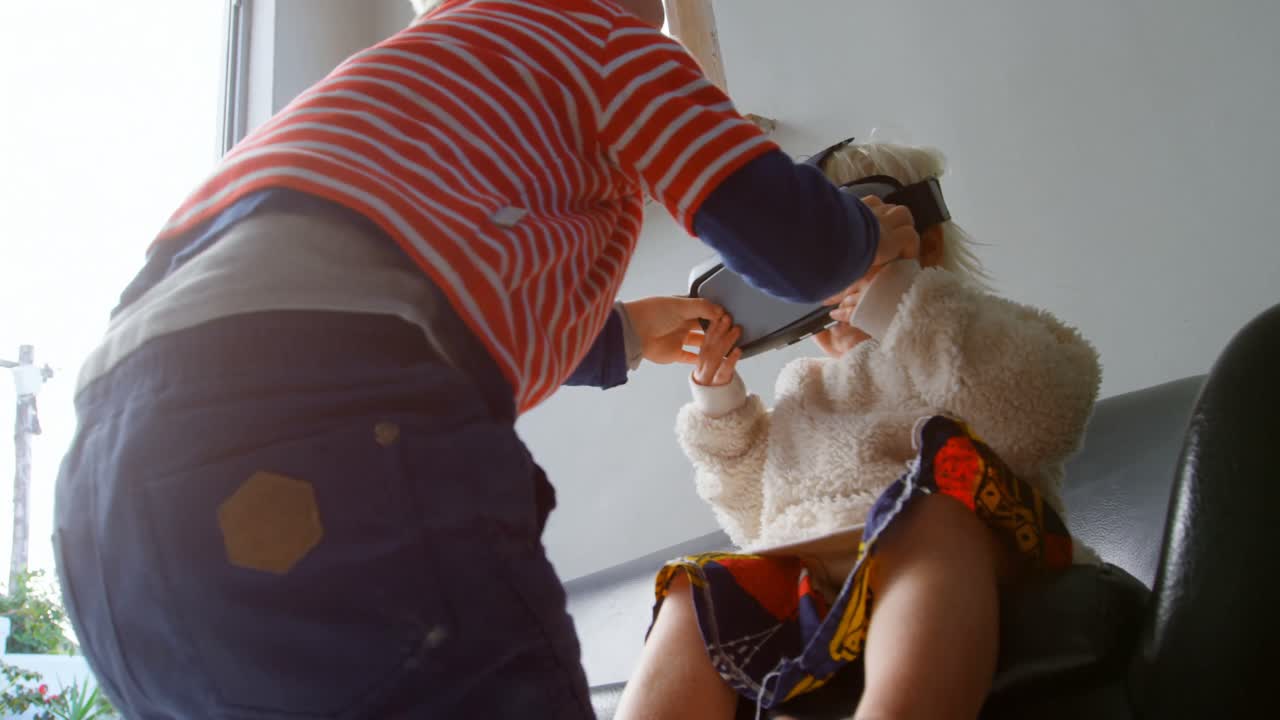 동생이 가상현실 헤드을 집에서 사용합니다.