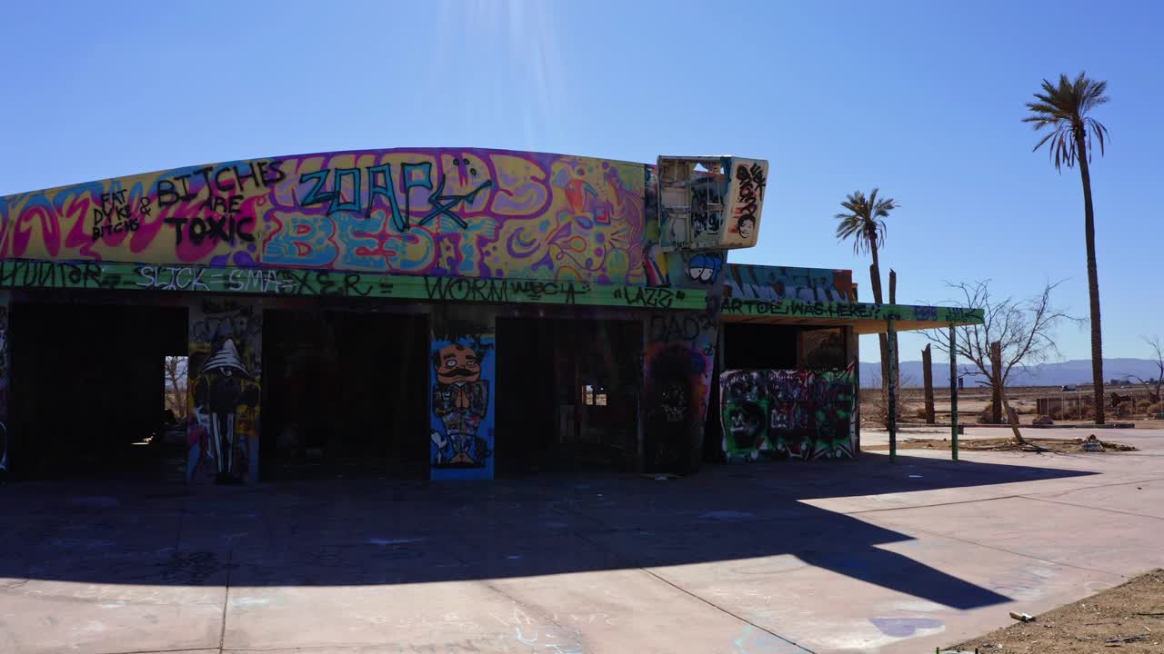 Dolly move in front of vacant, dilapidated building with graffiti on it