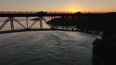 Silhouette-of-cars-driving-over-Deception-Pass-Bridge-at-sunset