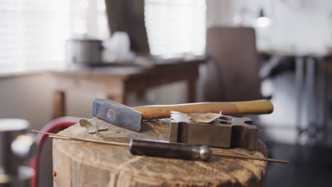 close up of handcraft tools lying on tree trunk in studio in slow motion