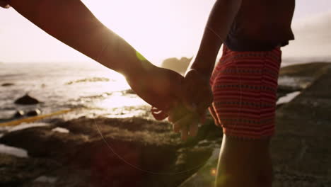 teniendo las manos, una pareja caminando a lo largo de la playa con una superposición de animación circular