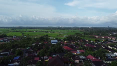 Shot-pans-with-parallax-effect-showcasing-the-horizon,-fields-in-the-background,-houses-in-the-foreground