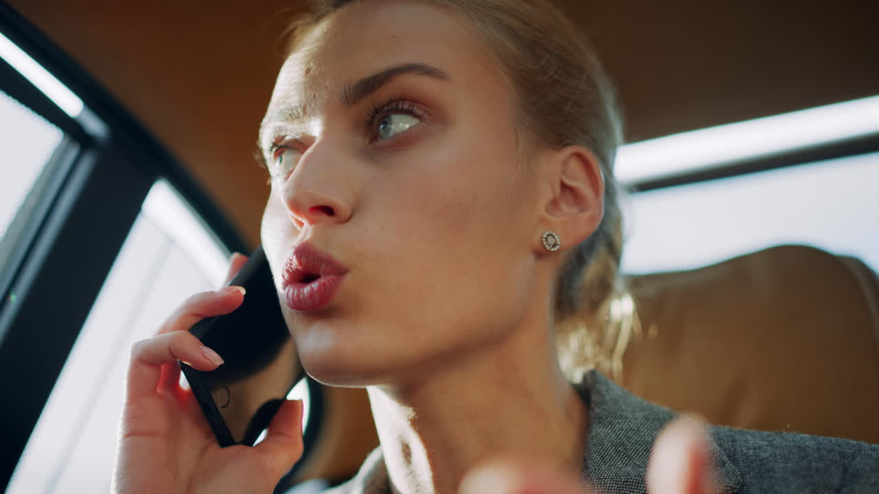 Angry business woman shouting by mobile phone at backseat. Girl arguing on phone
