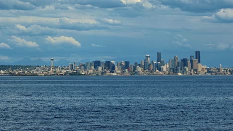 slow motion trucking right shot of the beautiful cityscape of seattle with the space needle, skyscrapers, and the coastline on a warm cloudy summer day in washington state, usa.