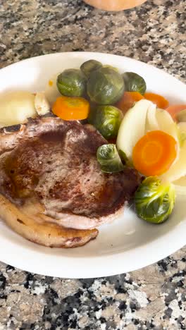 nutritious meal plate with steak and vegetables. vertical shot.