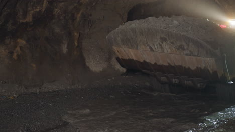 la maquinaria pesada de minería se mueve por un camino sucio lavado con agua