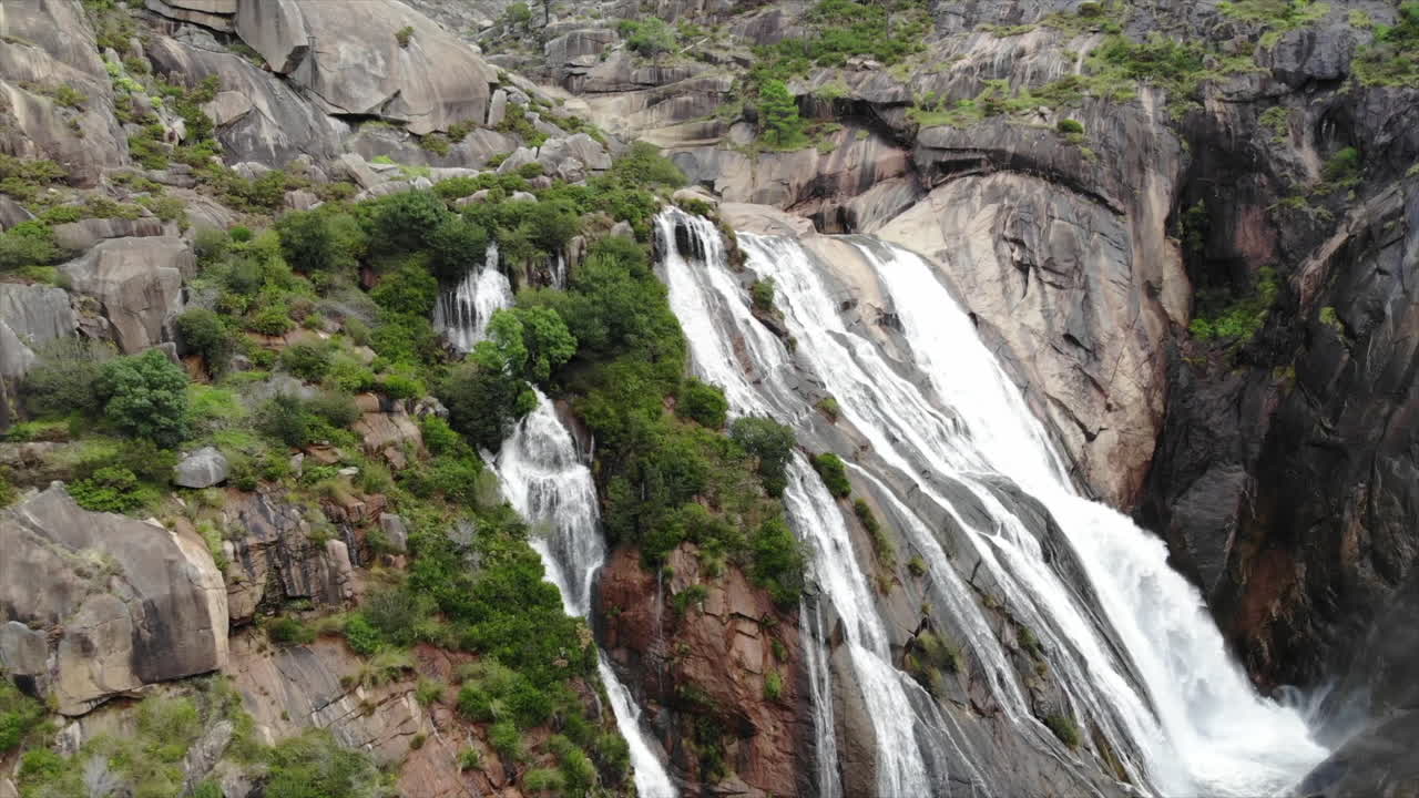 Water Cascade On The Majestic Cascada Del Ezaro In A Coruña, Spain - pullback drone shot, slow motion