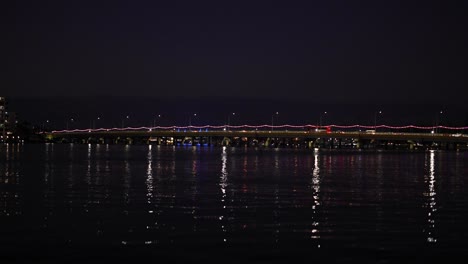 bridge lights reflecting on water at night