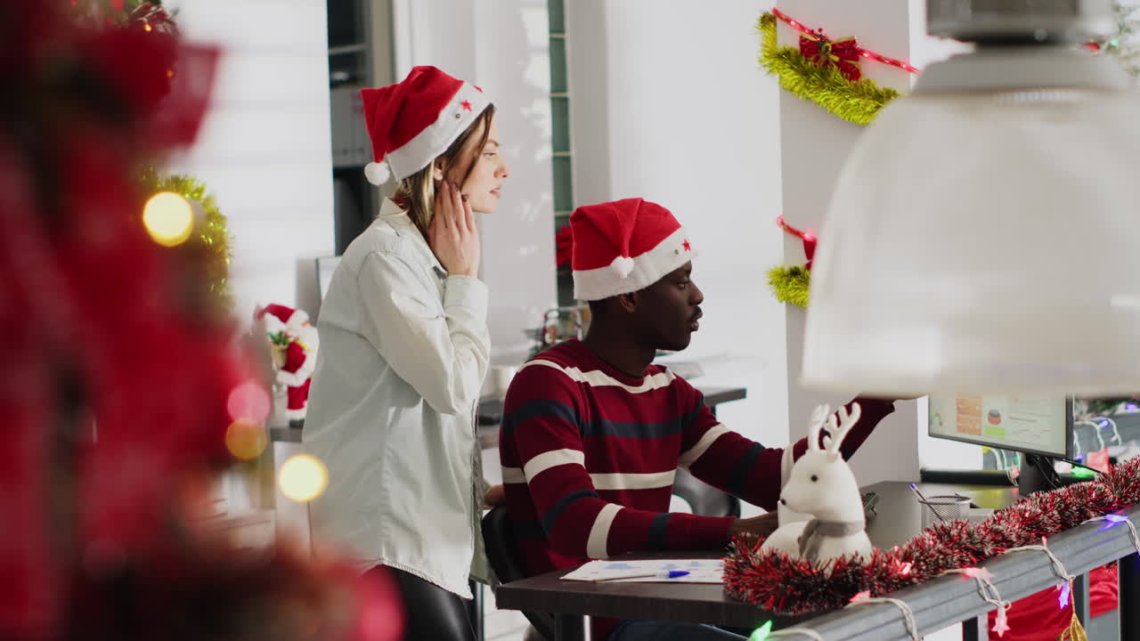 Festive office decorations with people wearing Santa hats