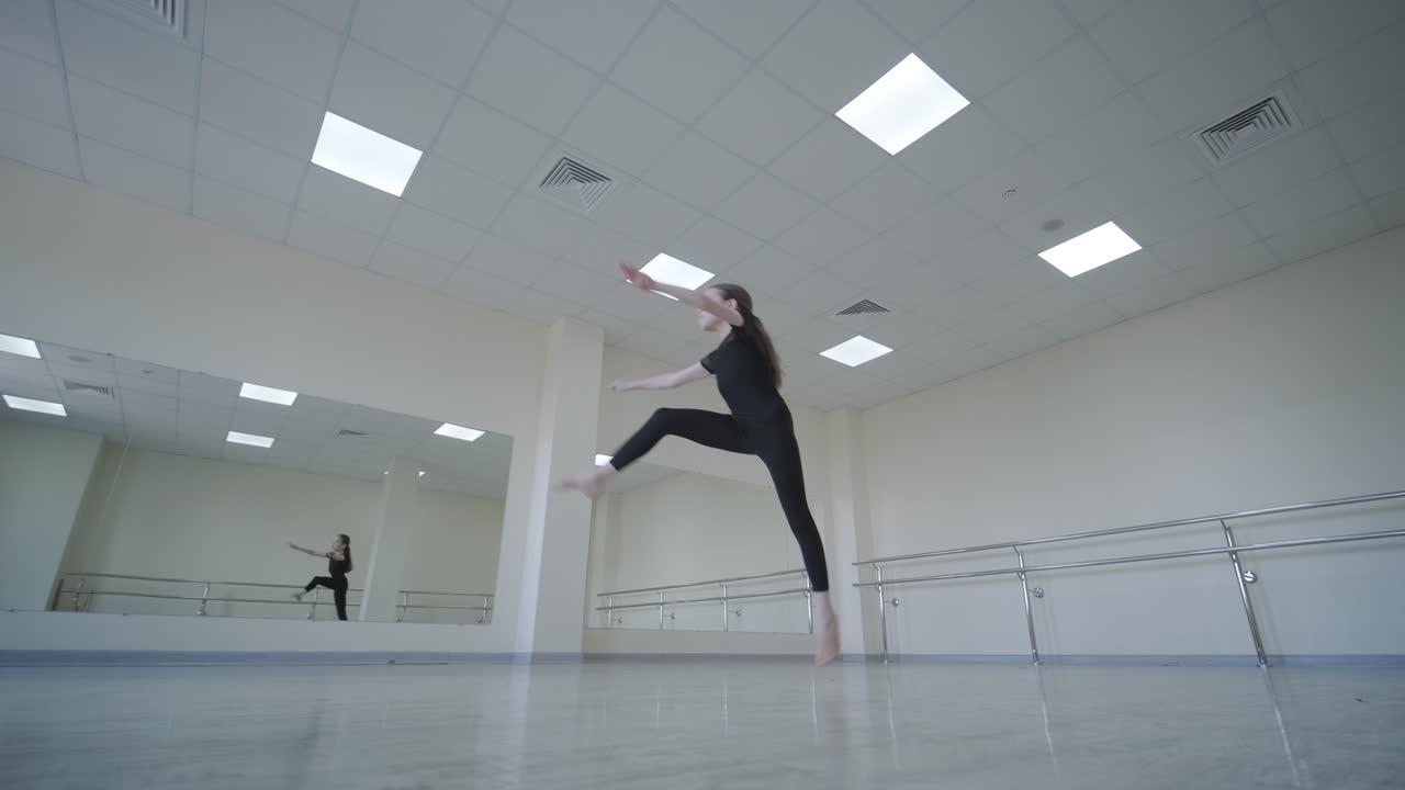 Giovane ballerina che pratica passi di danza in studio