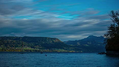 Nubes-Oscuras-Que-Pasan-Sobre-La-Región-Junto-Al-Lago-Y-Barcos-Anclados,-Timelapse