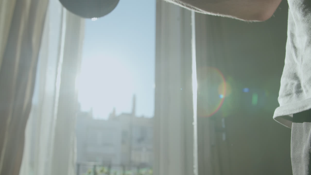 Man training with dumbbells in a sunlit room
