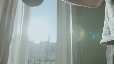 man training with dumbbells in a sunlit room