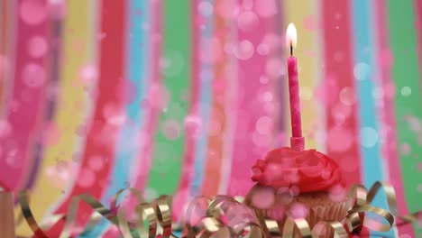 pastel con vela de cumpleaños rodeado por el efecto de burbujas rosadas