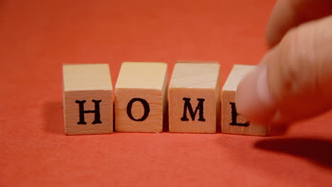 composing the word home with wooden letters on a red background